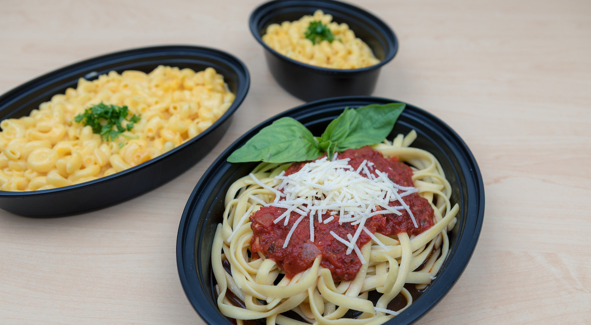 Takeout containers with spaghetti and macaroni and cheese